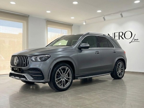 Mercedes-Benz GLE AMG Line — Front view Mallorca A matte Selenite Grey Magno Mercedes-Benz GLE AMG Line SUV is prominently displayed from a front three-quarter view in Mallorca.