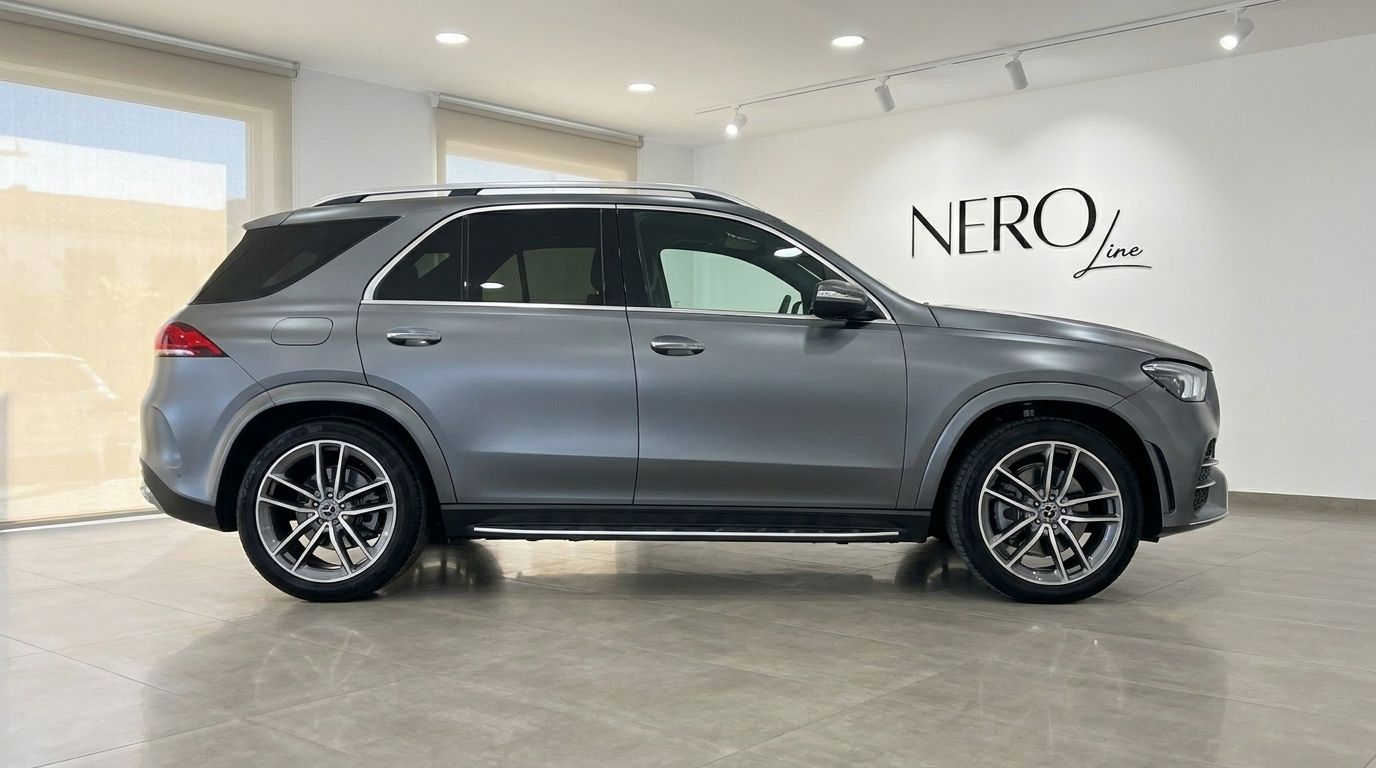 The Mercedes-Benz GLE AMG Line in matte Selenite Grey Magno is seen from its elegant side profile in a Mallorca showroom.