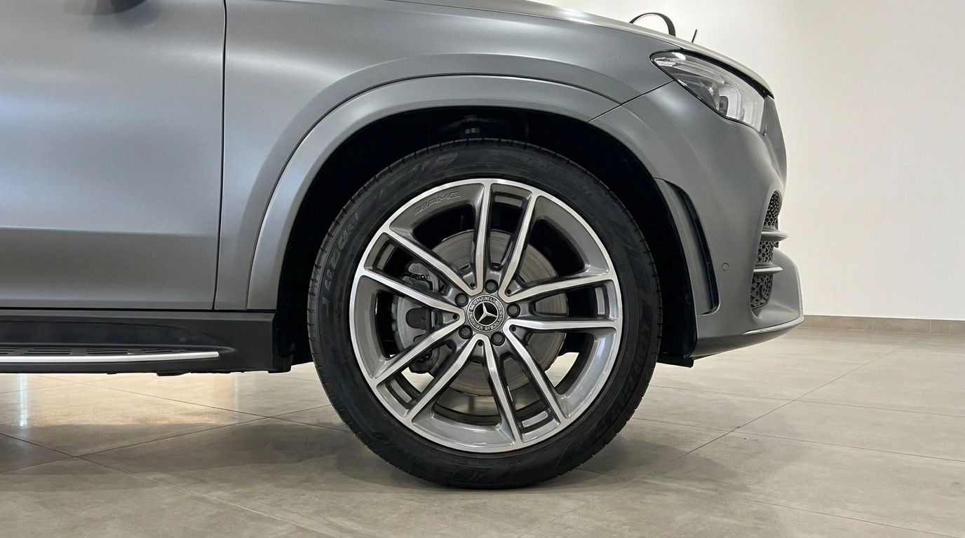 The front wheel, side profile, and part of the front bumper of the matte Selenite Grey Magno Mercedes-Benz GLE AMG Line in Mallorca.