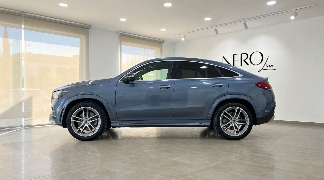 The 2022 Mercedes-Benz GLE Coupe in metallic steel blue, seen from its left side profile, displayed in a showroom in Mallorca.