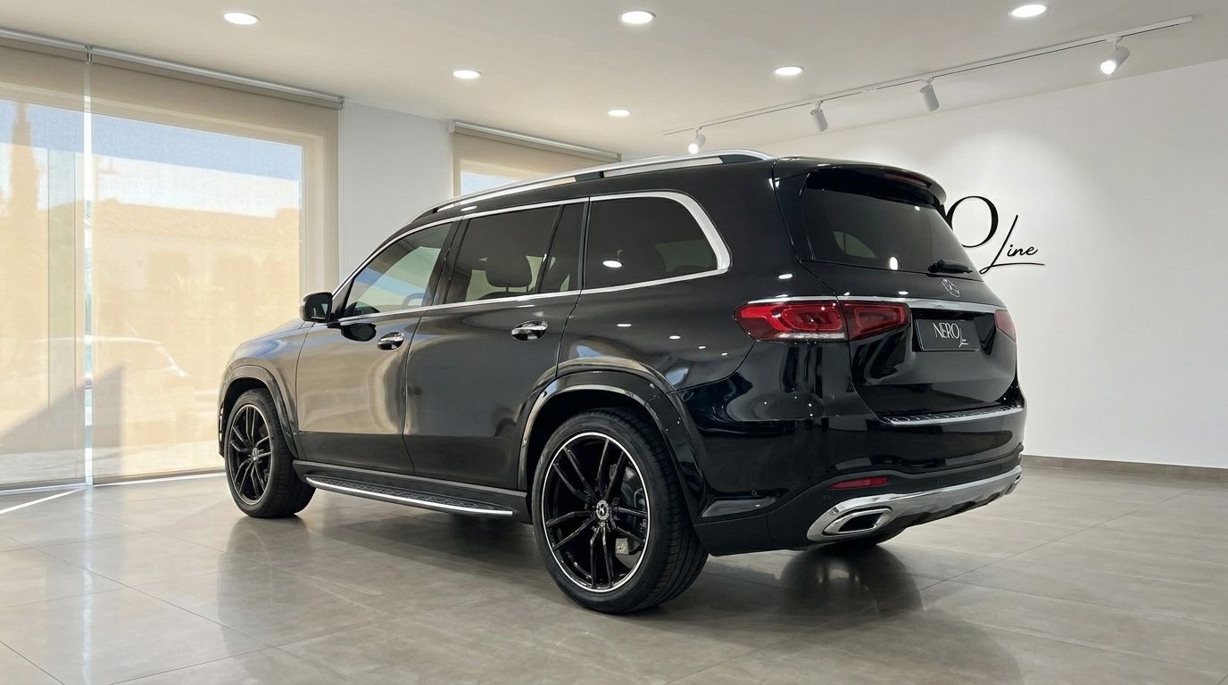 El Mercedes-Benz GLS 450 4Matic negro está aparcado en un concesionario, visto desde el ángulo trasero tres cuartos en Madrid.