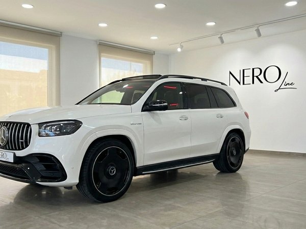 Mercedes-Benz GLS 63 AMG — Showroom in Alicante The white Mercedes-Benz GLS 63 AMG is showcased from a front three-quarter angle in a bright showroom in Alicante.