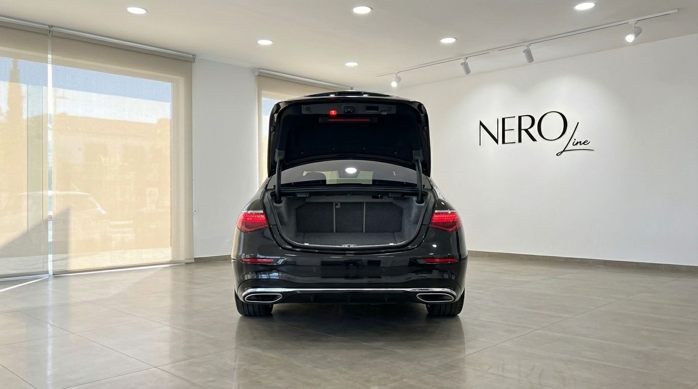 The rear view of the black Mercedes-Benz S350d with its trunk open, parked in a bright showroom in Alicante.