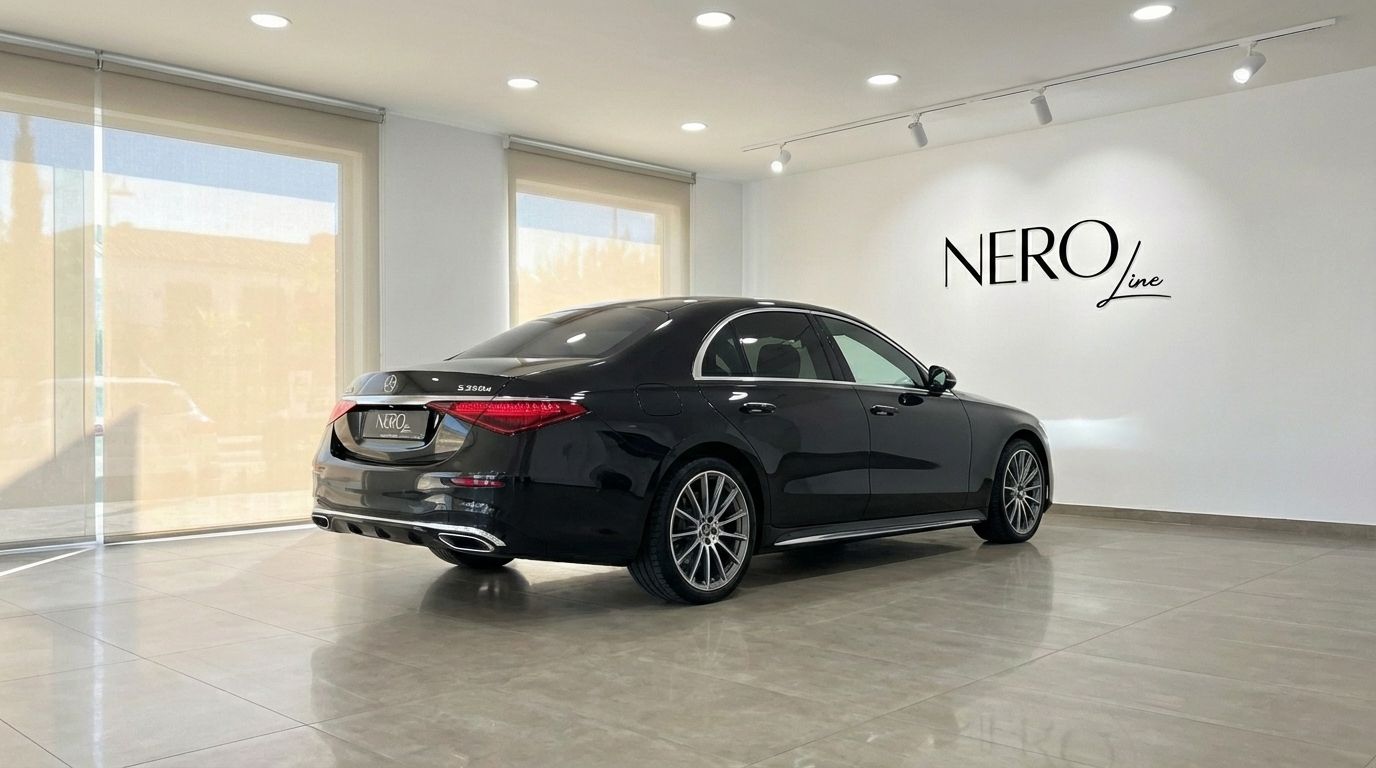 The metallic black Mercedes-Benz S350d is showcased from a rear three-quarter angle in a showroom in Alicante.