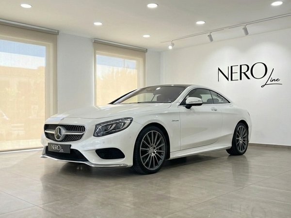 Mercedes-Benz S500 Coupe — Alicante showroom A white Mercedes-Benz S500 Coupe is showcased in a modern Alicante showroom, captured from a front three-quarter angle.