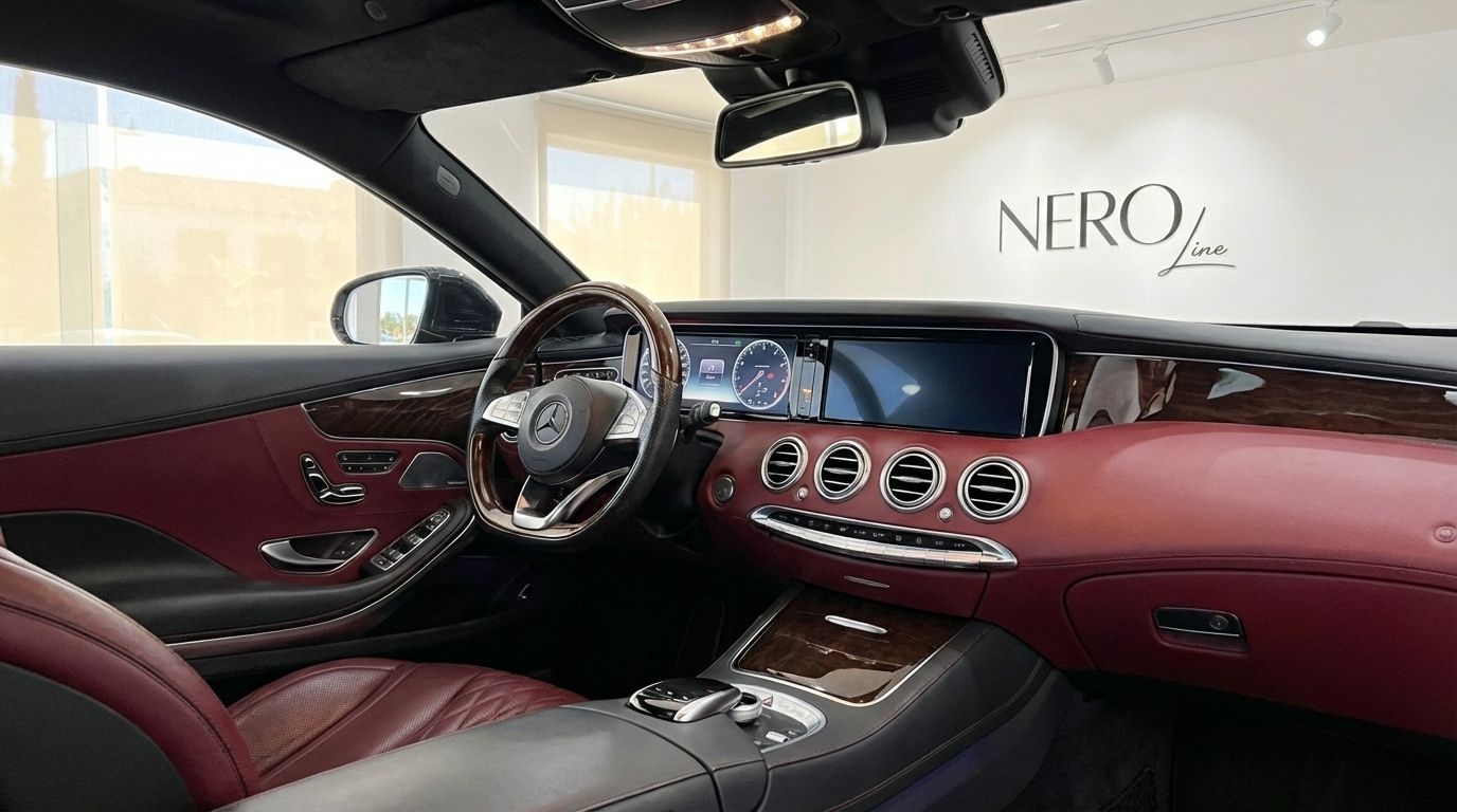 The luxurious interior of the Mercedes-Benz S500 Coupe in Alicante, featuring a red leather dashboard, steering wheel, and dual infotainment screens.