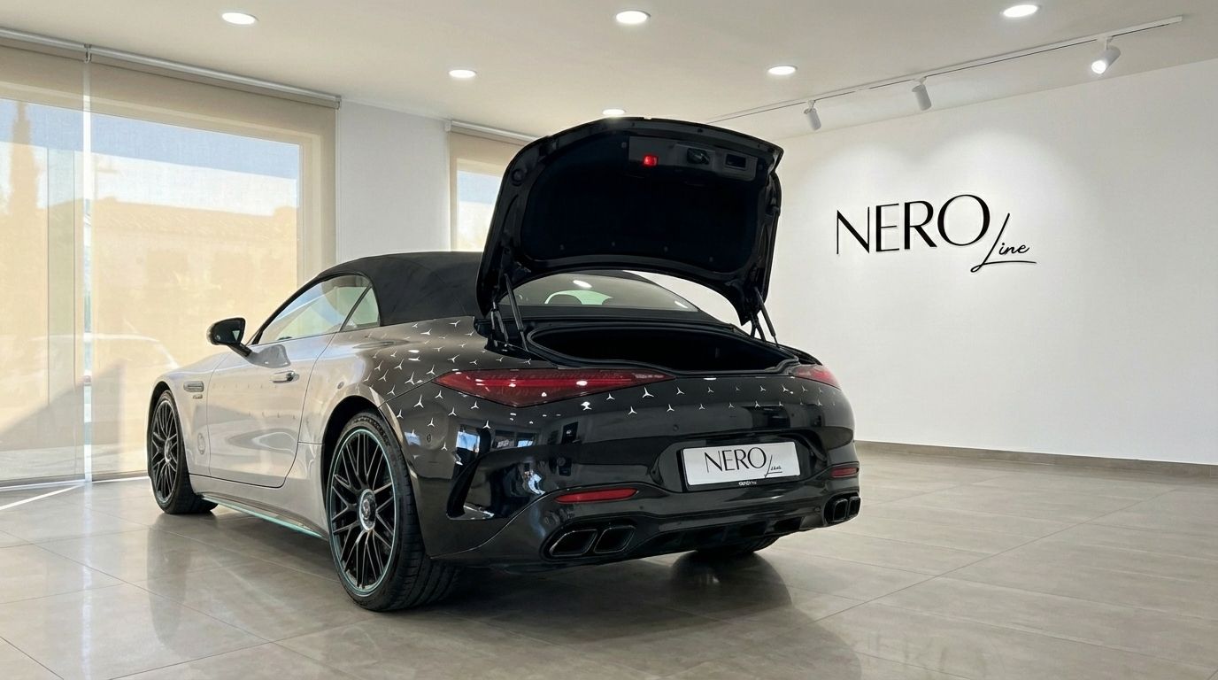 The 2023 Mercedes-Benz SL43 AMG, a grey convertible, is shown from the rear three-quarter with its trunk open in an Alicante showroom.