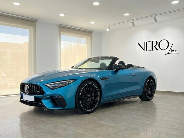 Mercedes-Benz SL43 AMG Roadster — Showroom view Alicante A turquoise blue Mercedes-Benz SL43 AMG Roadster, convertible top down, is showcased in a modern showroom in Alicante.