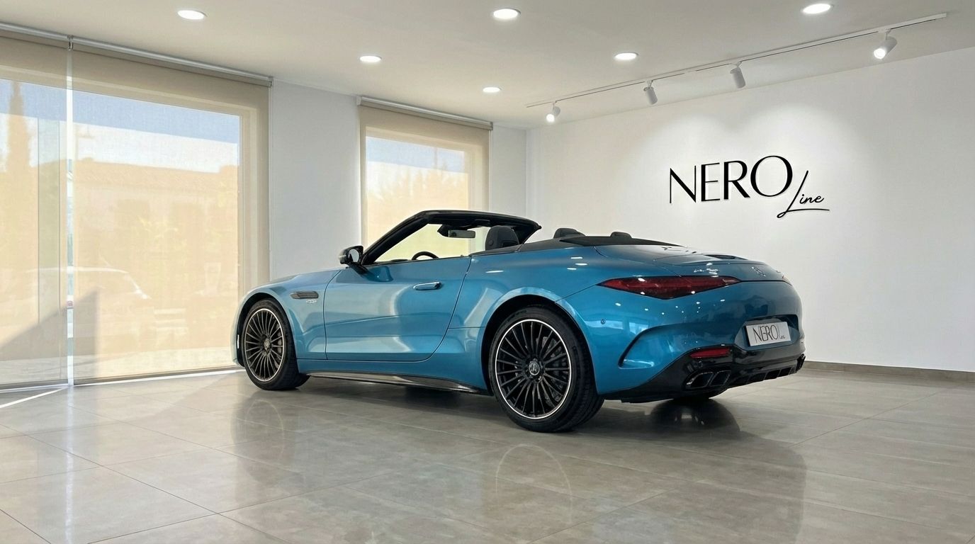 A stunning turquoise blue Mercedes-Benz SL43 AMG Roadster is showcased from a rear three-quarter view with its top down in a bright Alicante showroom.