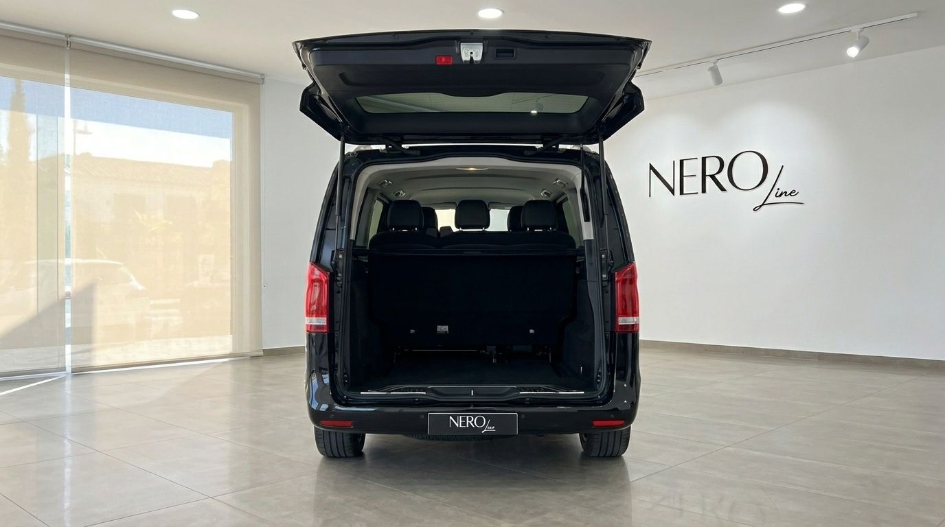 Black Mercedes-Benz V-Class 250d, rear view with the trunk open, showing the spacious cargo area and rear seats, in Alicante.