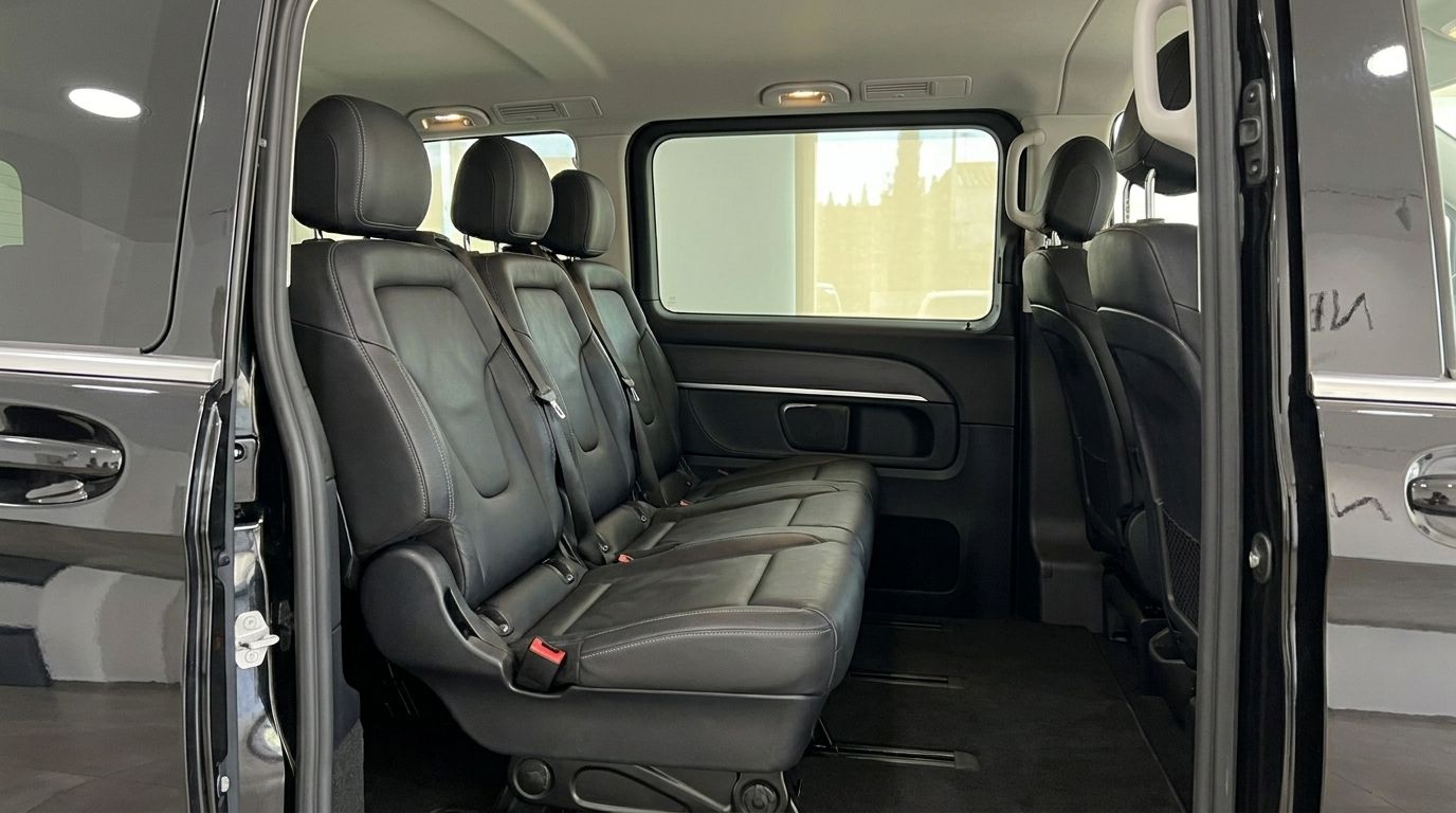 Mercedes-Benz V-Class 250d's spacious rear passenger cabin with black leather seats and open sliding door in Alicante.