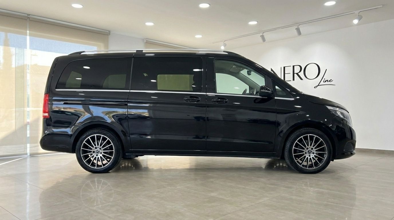 The black Mercedes-Benz V-Class 250d is shown from a sleek side profile, parked in a modern showroom in Alicante.