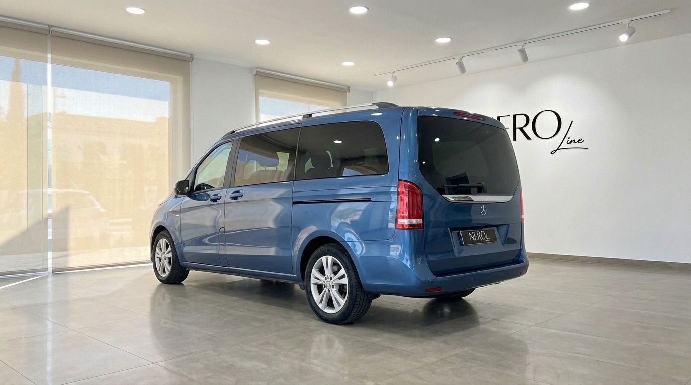 The metallic blue Mercedes-Benz V-Class 300d Extralang is parked in a showroom in Mallorca, viewed from the rear three-quarter angle.