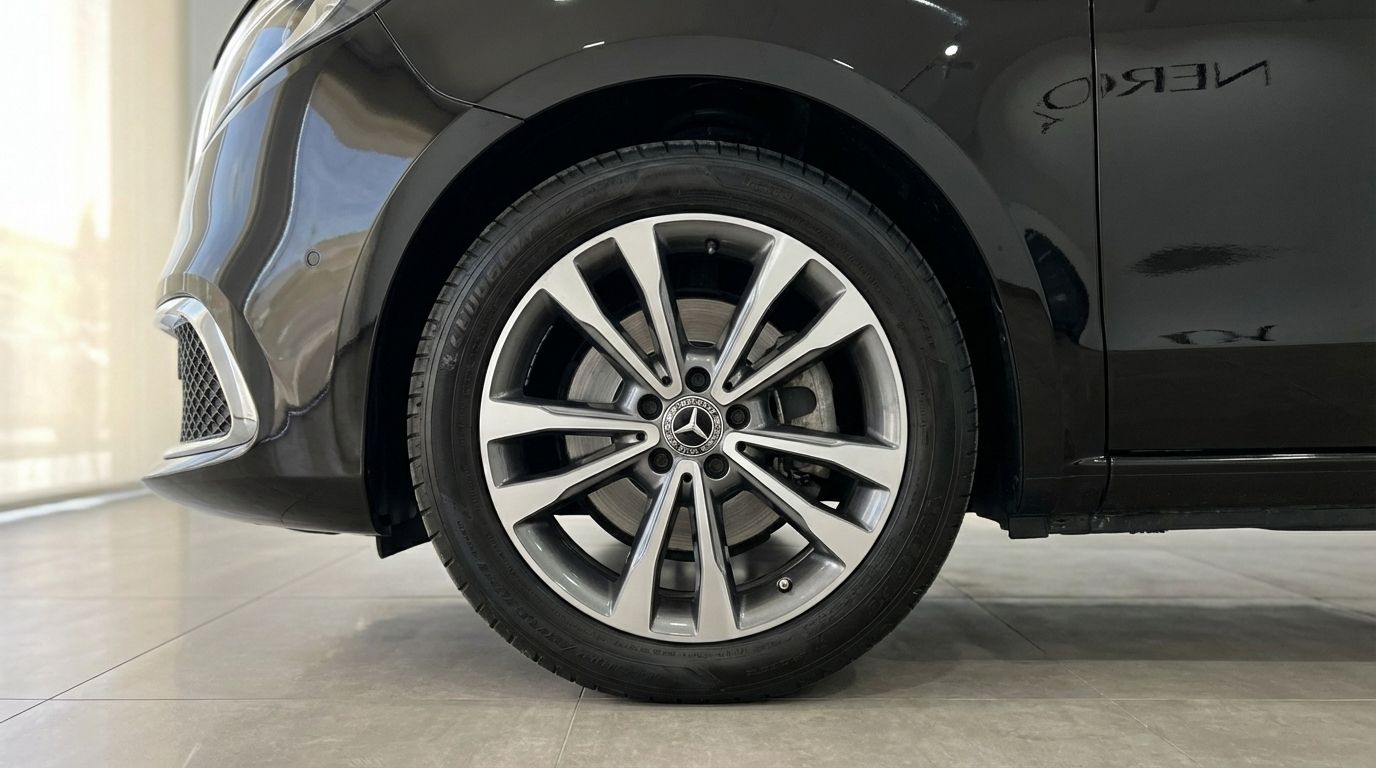 Una vista detallada de la rueda delantera y el parachoques inferior del Mercedes-Benz V250d, mostrando su elegante diseño en Madrid.