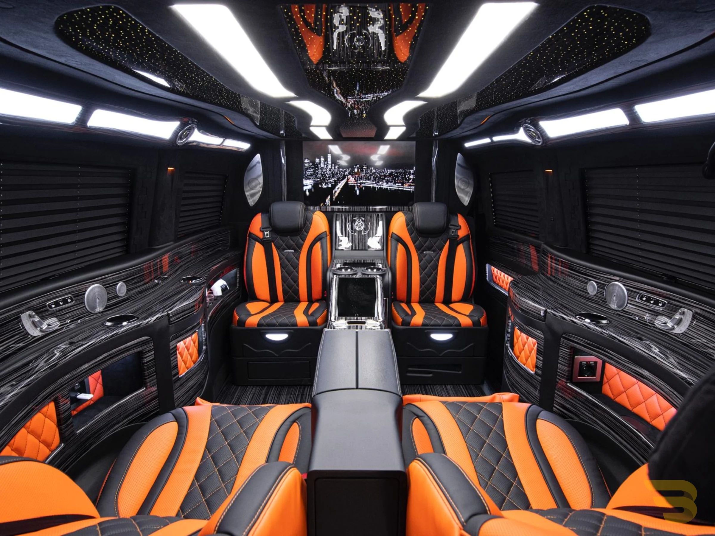 The Mercedes-Benz V250d Hermes VIP luxury interior in Barcelona features bespoke orange and black seating, a starry ceiling, and an entertainment screen.