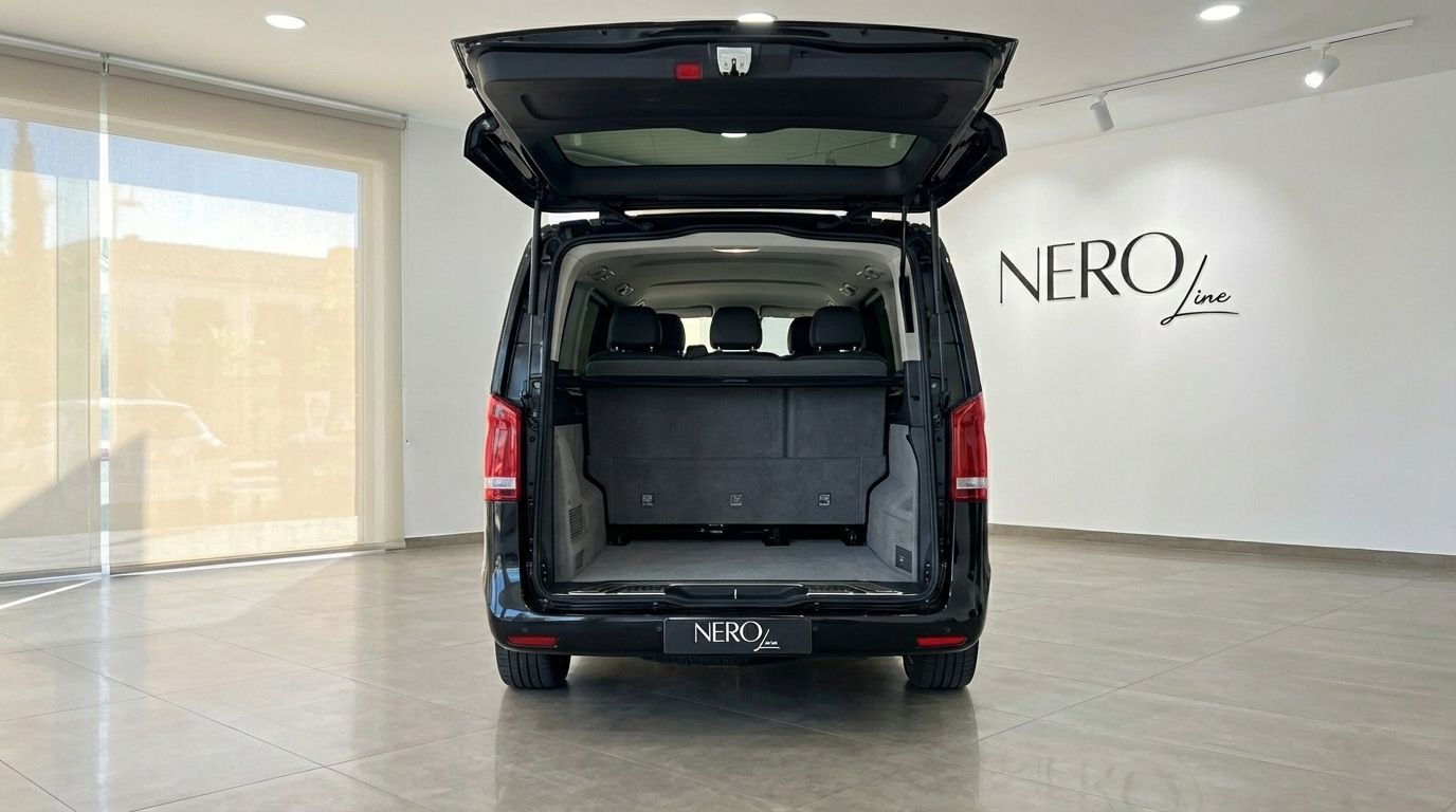 El Mercedes-Benz V250d negro muestra su parte trasera con el maletero abierto, revelando el amplio espacio de carga y asientos en Madrid.