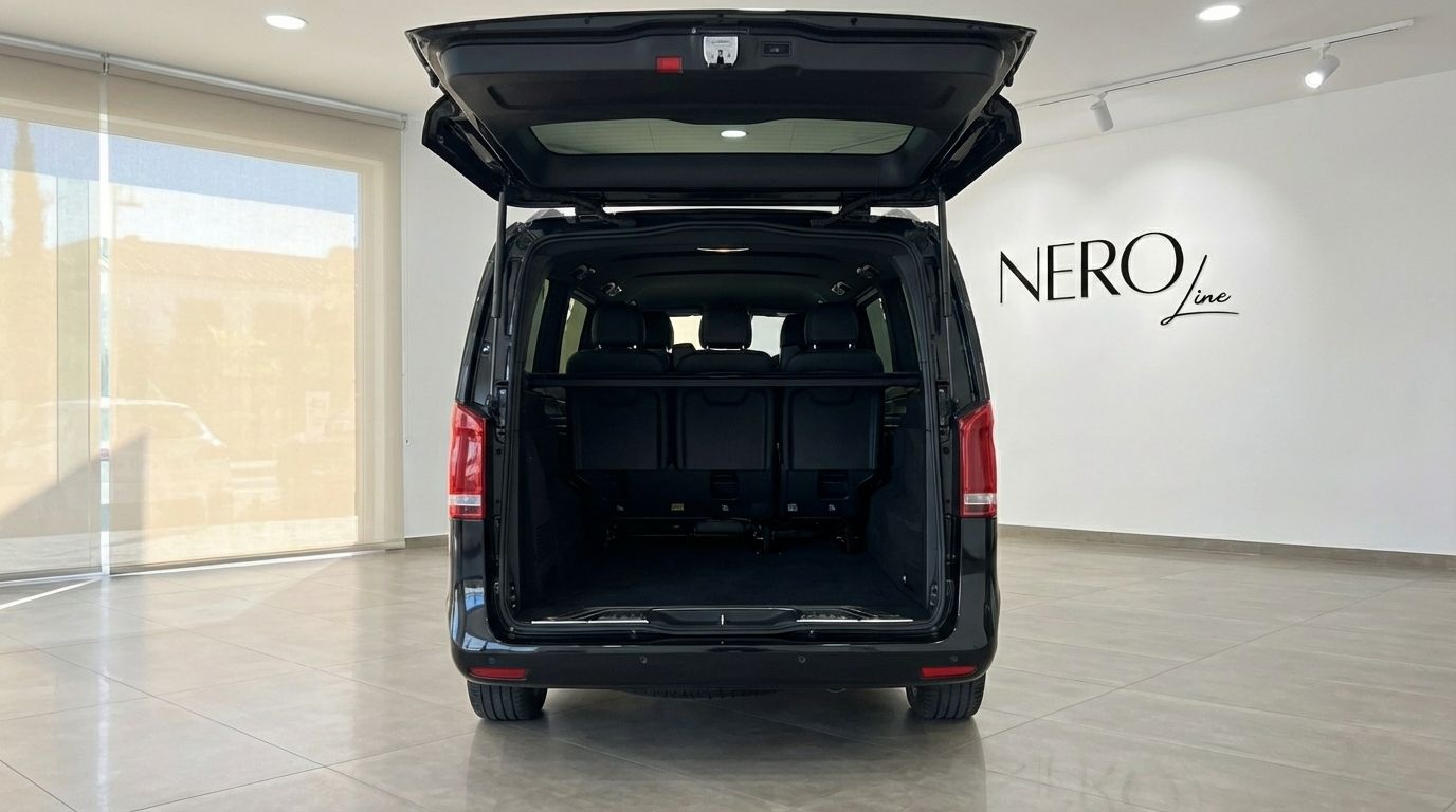 The black Mercedes-Benz V250d shows its spacious rear cargo area with the boot open in a Marbella showroom.