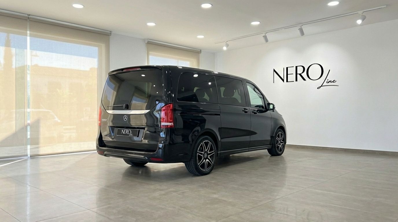 A black Mercedes-Benz V250d van, seen from a rear three-quarter angle, parked in a showroom in Marbella.