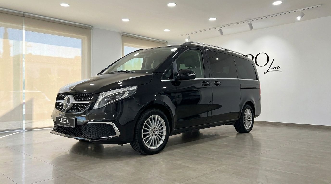 Una elegante furgoneta Mercedes-Benz V300 negro obsidiana metálico brillante se exhibe en vista tres cuartos delanteros en un luminoso showroom de Madrid.