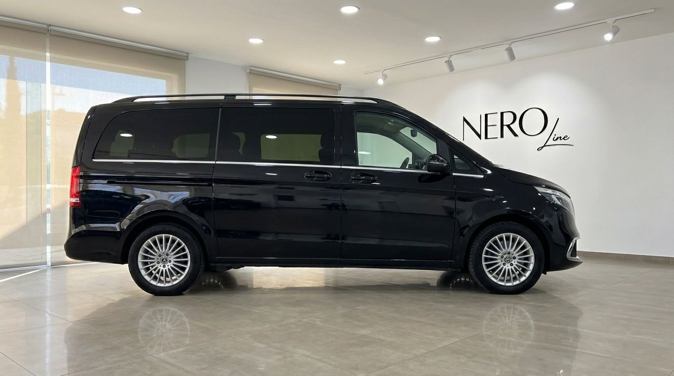 La furgoneta negra Mercedes-Benz V300 se exhibe en un concesionario, destacando su elegante perfil lateral en Madrid.