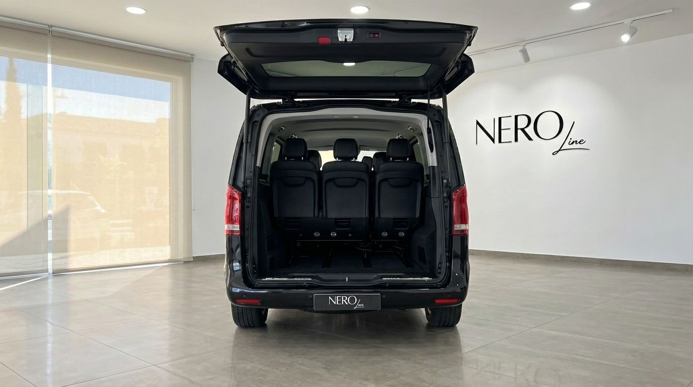 El Mercedes-Benz V300 negro se muestra desde la parte trasera con el portón abierto, revelando el espacioso interior y tres asientos negros en un showroom de Madrid.