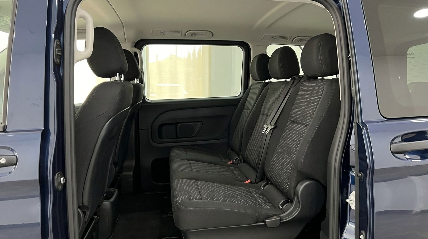 The Mercedes-Benz Vito Tourer's spacious interior features two rows of black fabric rear seats with the dark blue exterior visible.