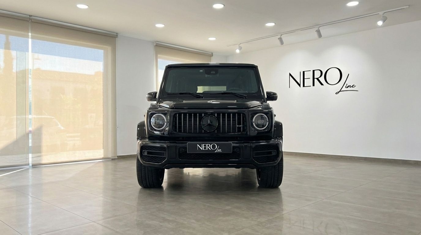 Front view of the glossy black 2025 Mercedes G63 AMG parked in a showroom in Madrid, showcasing its imposing grille.