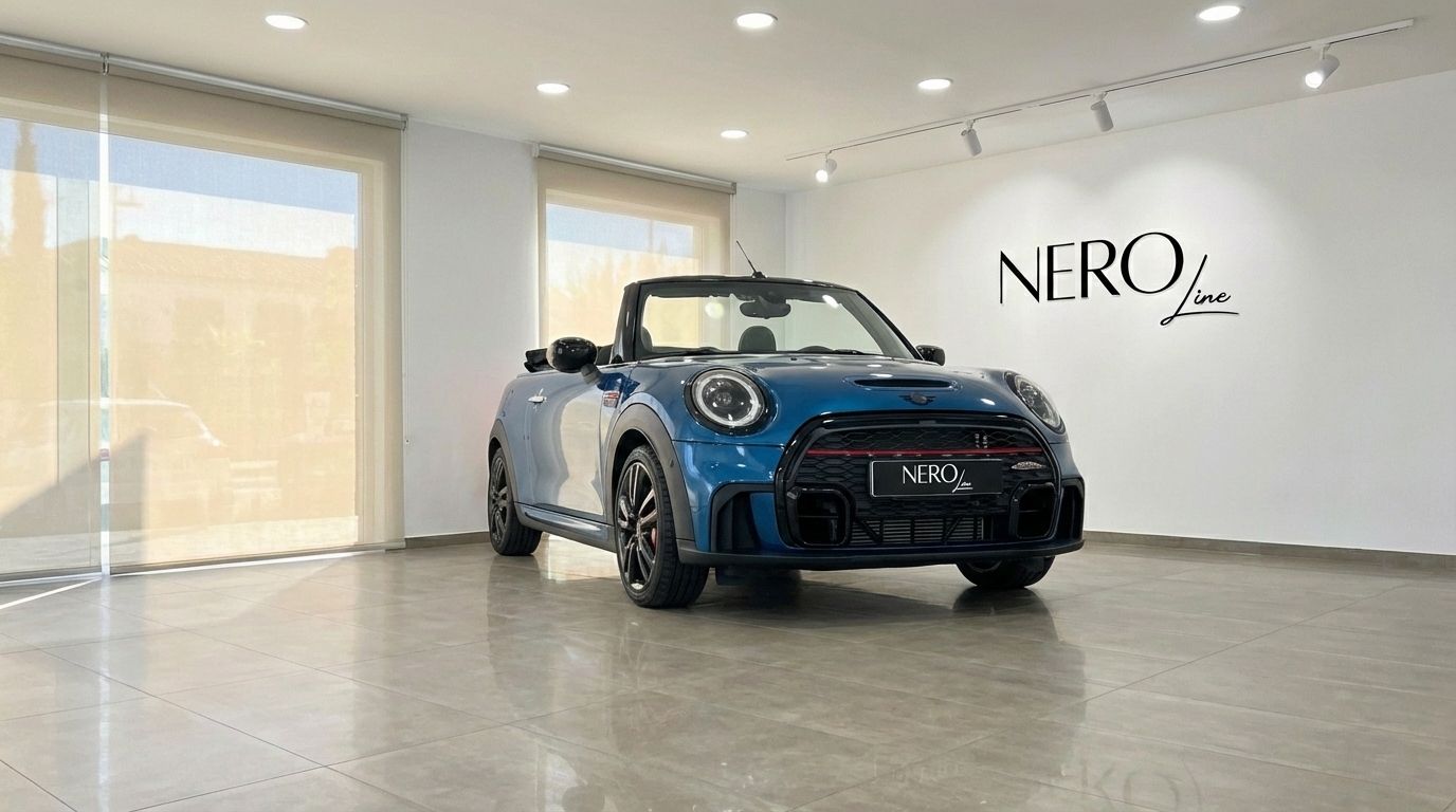 A metallic blue Mini Cooper John Works Convertible, with its top down, is parked in a showroom in Ibiza.
