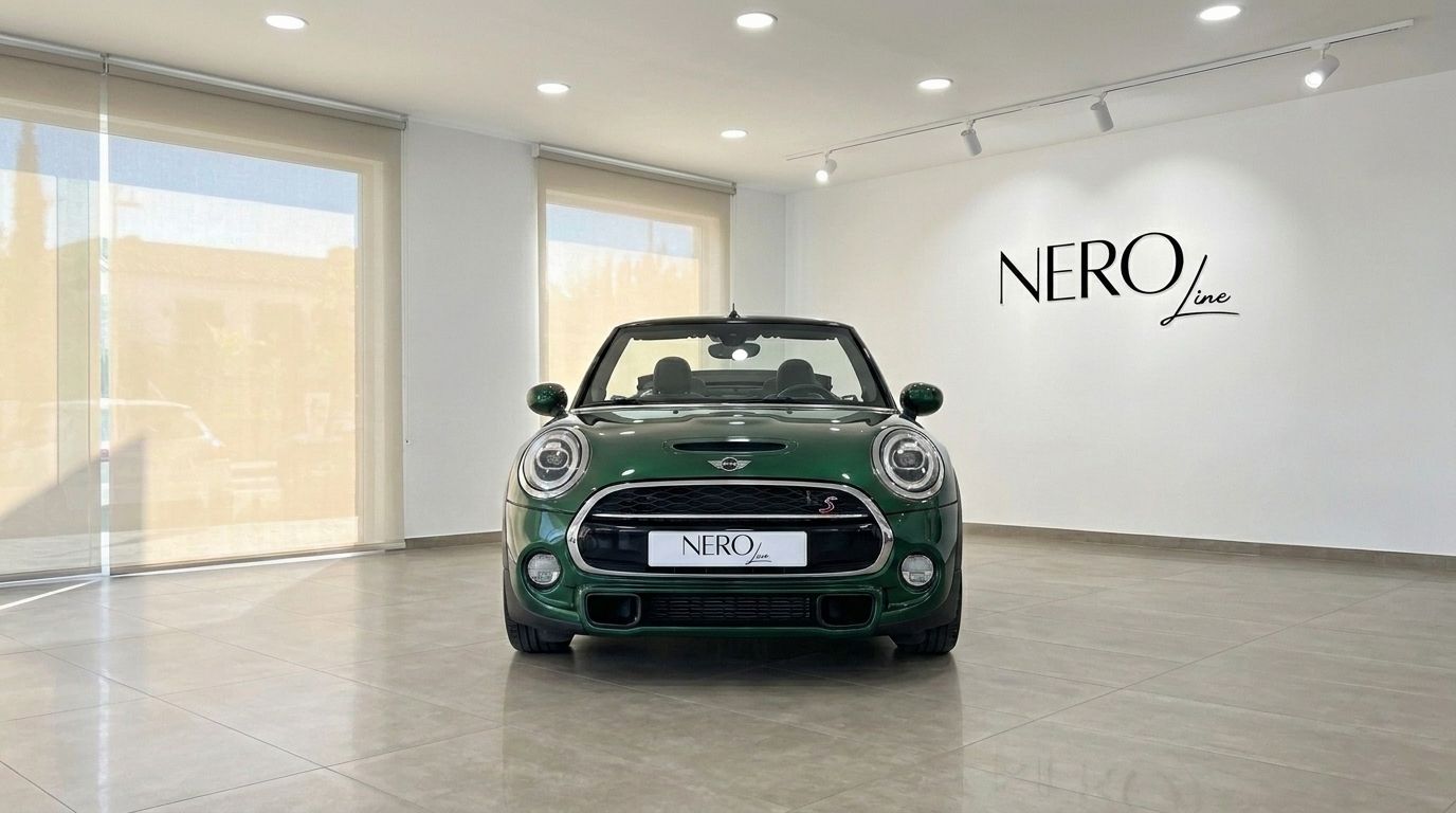The green 2021 Mini Cooper S Cabrio convertible is parked head-on in a showroom in Mallorca, showcasing its iconic front design.