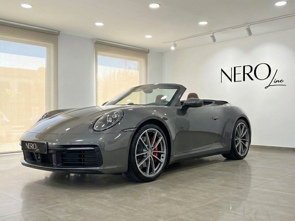 Porsche 911 Carrera S Cabrio — Showroom Marbella A grey Porsche 911 Carrera S Cabrio with its top down, parked in a bright showroom in Marbella.