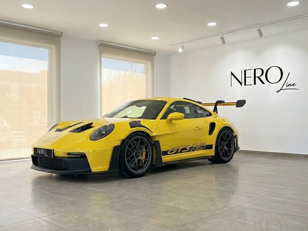 Porsche 911 GT3 RS — Luxury supercar in Ibiza A gloss yellow Porsche 911 GT3 RS is parked in a showroom with the Nero Line logo on the wall in Ibiza.