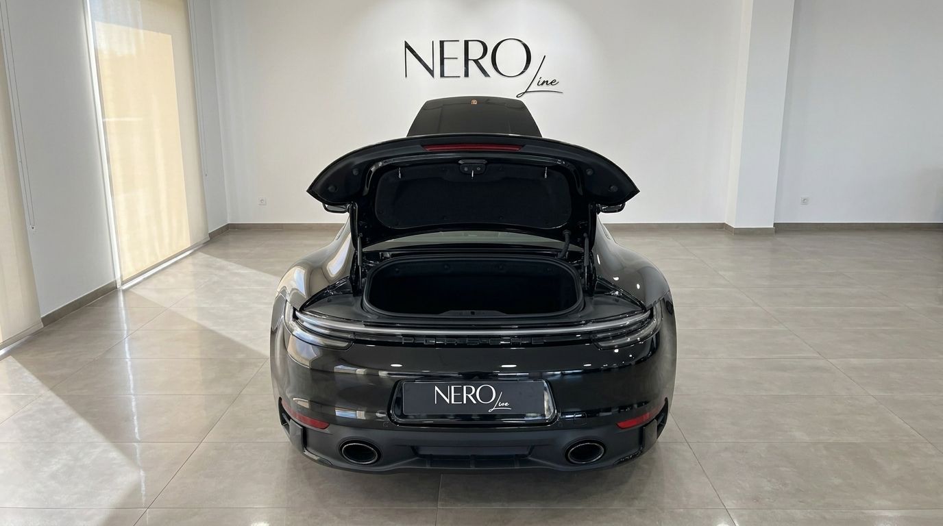 The black Porsche Carrera 4S 992.2 Coupé is shown from the rear with its rear compartment and front hood open in Madrid.