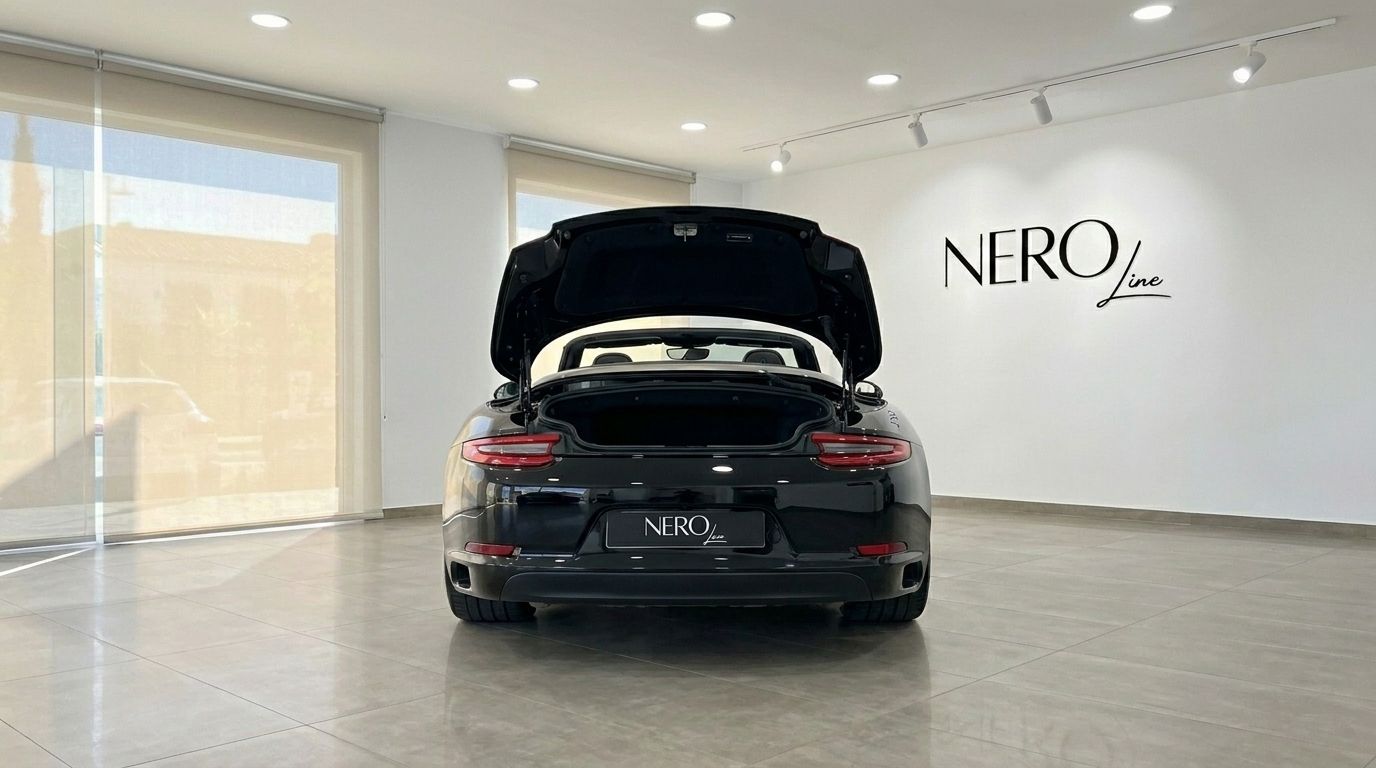 El Porsche Carrera 4S Convertible 2021 negro brillante se muestra desde la parte trasera con el maletero abierto en un concesionario de Madrid.