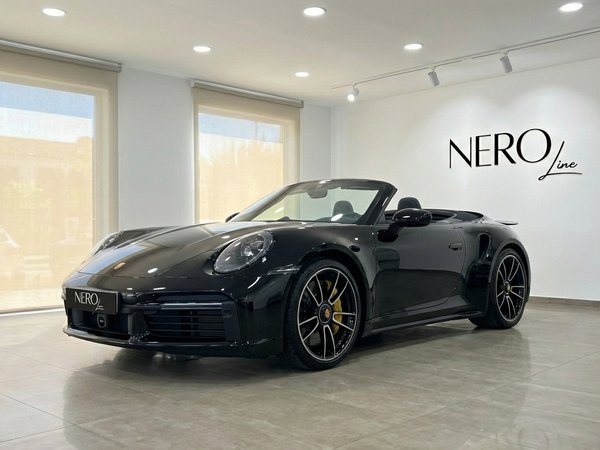 Porsche Carrera 911 Turbo S Cabrio 992 — Descapotable de lujo Porsche Carrera 911 Turbo S Cabrio 992 negro, un descapotable de lujo, mostrado desde un ángulo frontal tres cuartos en Madrid.