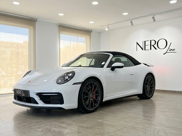 Porsche Carrera S Cabriolet 992.2 — Madrid Showroom A white 2025 Porsche Carrera S Cabriolet 992.2 is parked in a showroom in Madrid, shown from a front three-quarter angle.