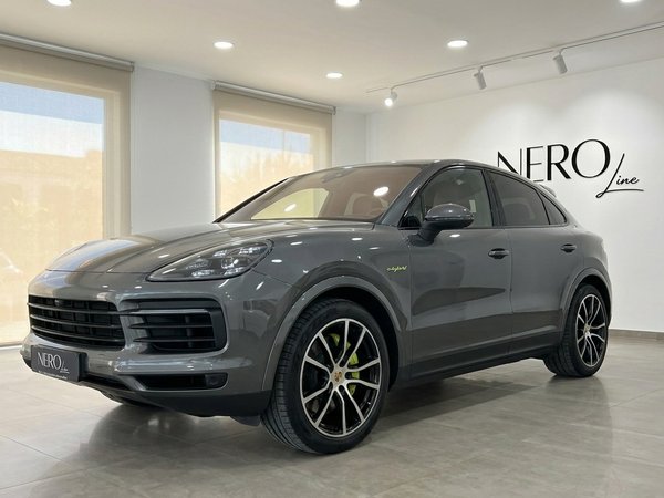 Porsche Cayenne — Front three-quarter showroom view The gloss Quarzite Grey Metallic 2022 Porsche Cayenne is showcased from a front three-quarter angle inside a modern showroom in Alicante.