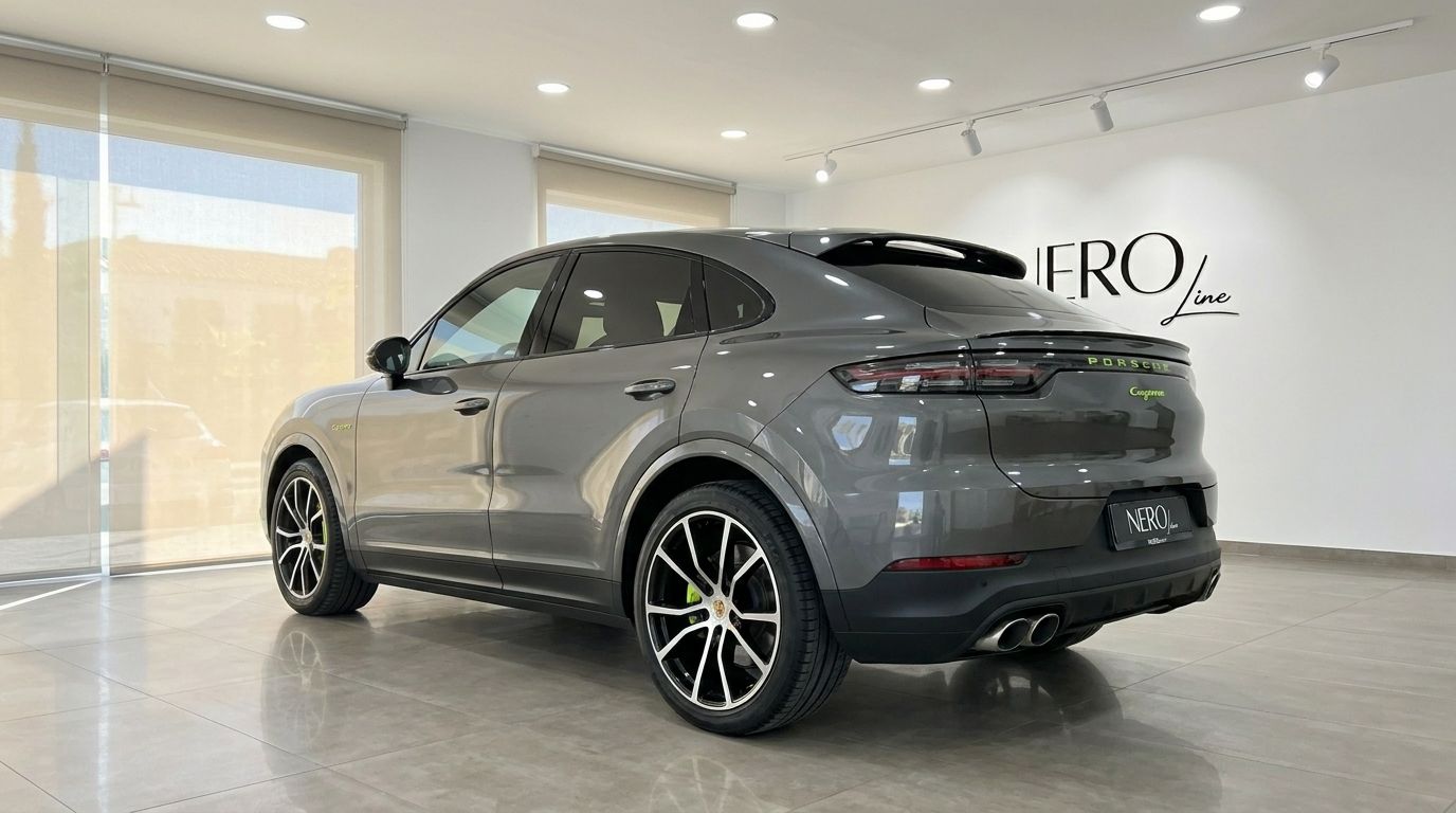 The grey 2022 Porsche Cayenne is showcased from a rear three-quarter angle, highlighting its design in an Alicante showroom.