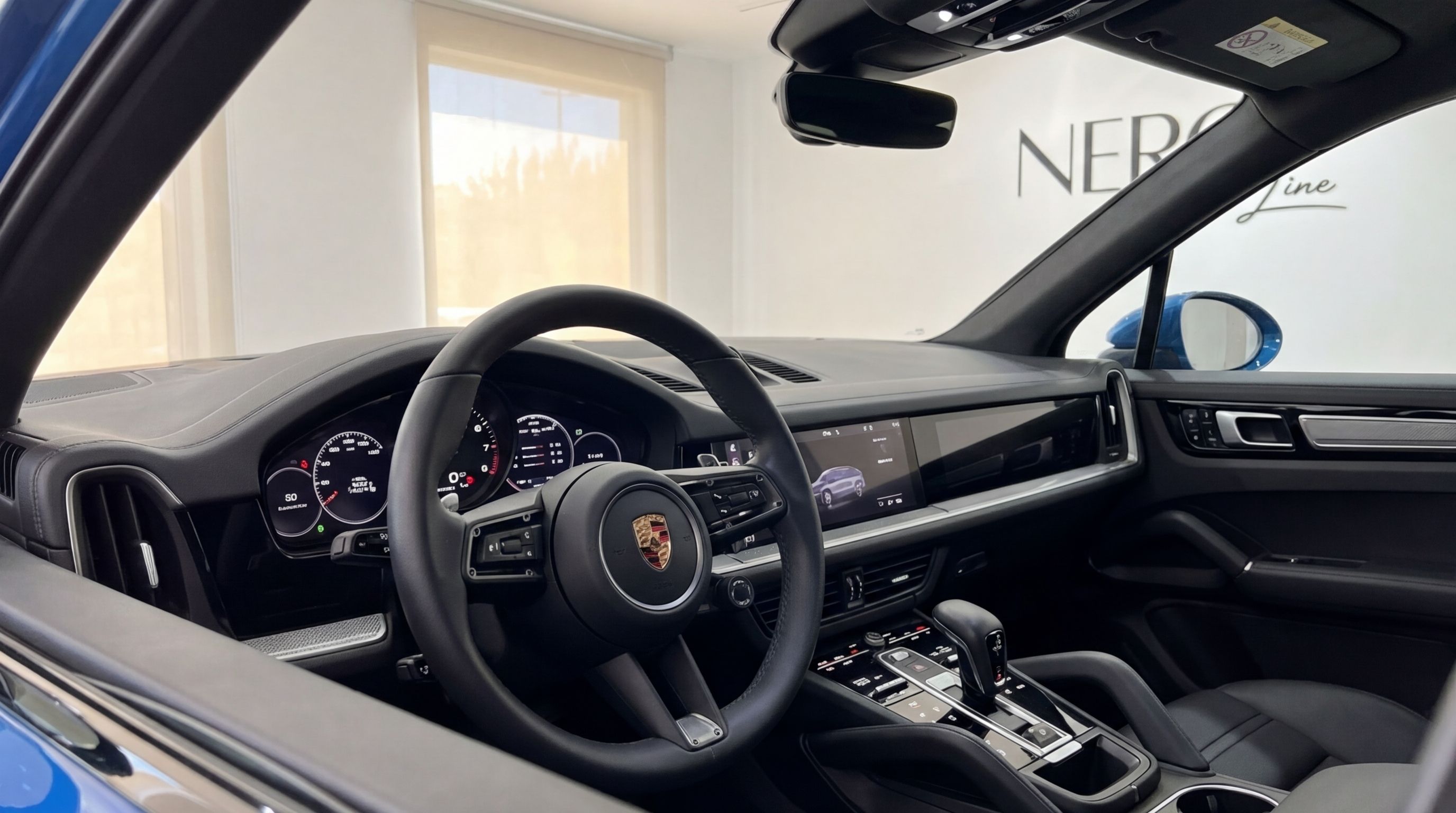 The luxurious interior of the Porsche Cayenne, showcasing the steering wheel, digital dashboard, and sleek center console in Mallorca.