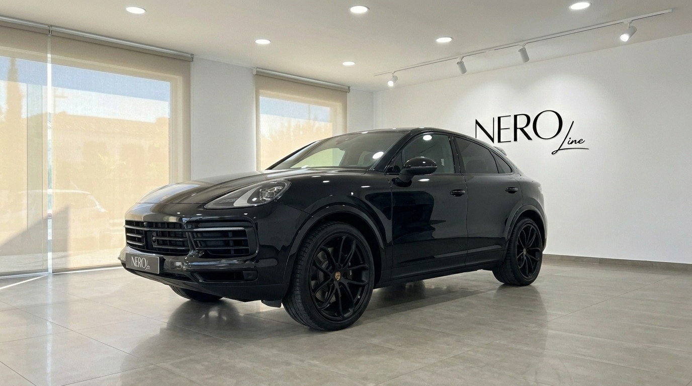 Porsche Cayenne — Showroom display in Alicante A sleek black Porsche Cayenne is displayed in a modern showroom with large windows, Alicante.