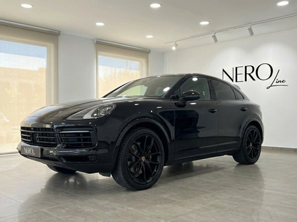 Porsche Cayenne — Showroom display in Alicante A sleek black Porsche Cayenne is displayed in a modern showroom with large windows, Alicante.