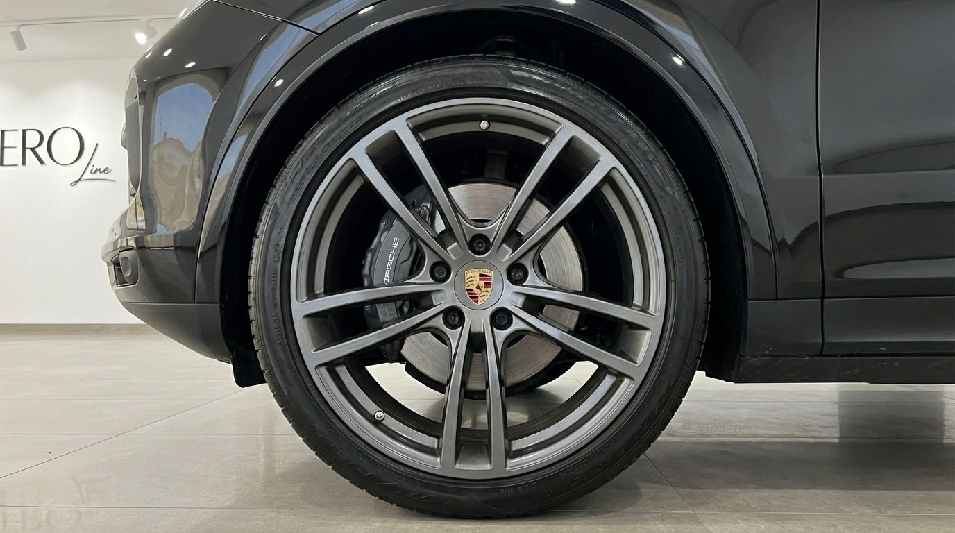 The black Porsche Cayenne's front wheel, featuring a grey multi-spoke rim and brake caliper, is shown in Barcelona.