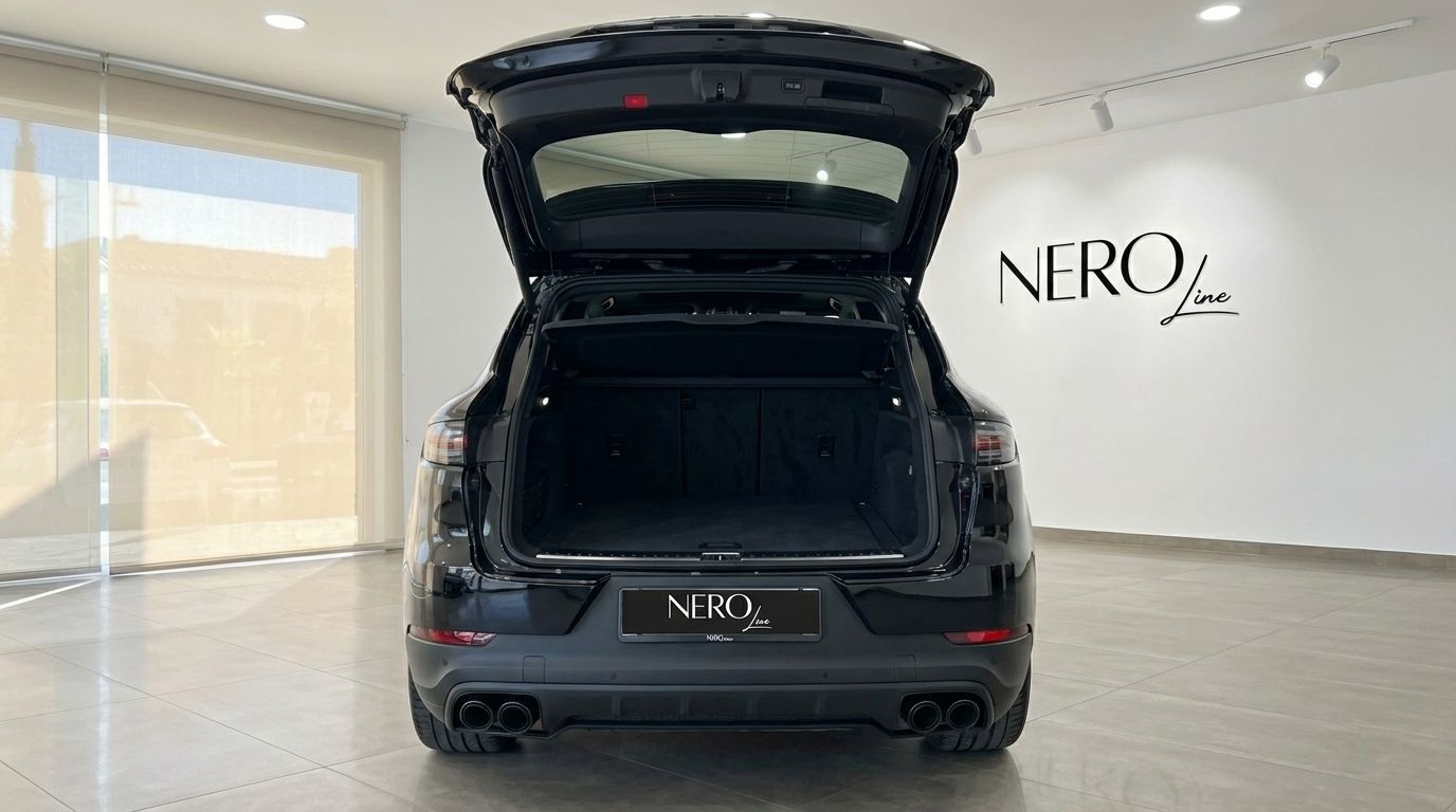The black 2022 Porsche Cayenne is shown from the rear with its trunk open, revealing the cargo space in Barcelona.