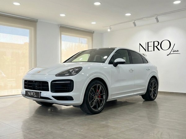 Porsche Cayenne Turbo GT — Showroom Valencia The white 2021 Porsche Cayenne Turbo GT is showcased from a front three-quarter angle in a bright Valencia showroom.