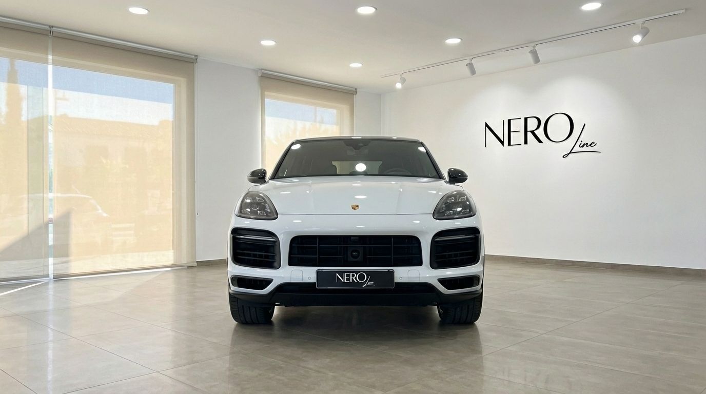 The white 2021 Porsche Cayenne Turbo GT is shown from the front in a modern showroom in Valencia.