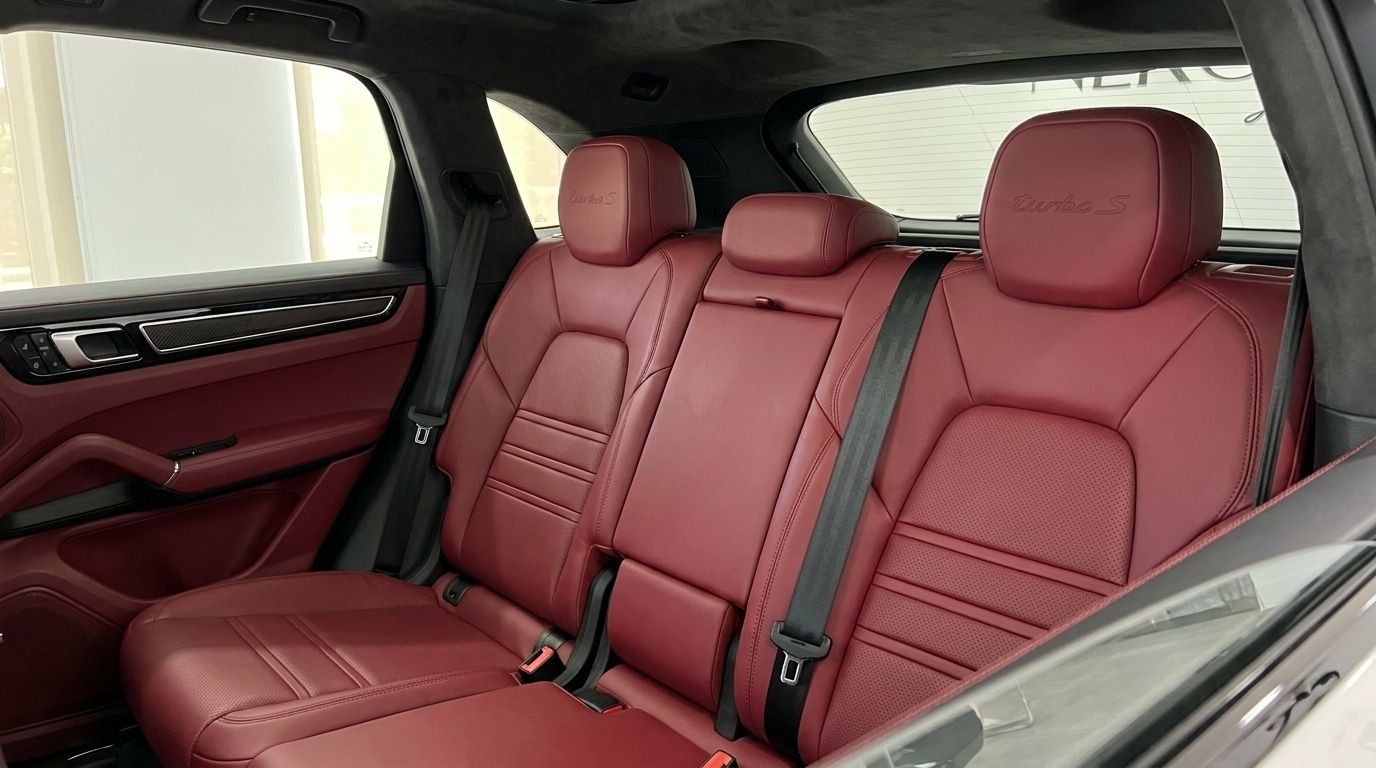 The luxurious red leather rear seats with 'Turbo S' embroidery in the Porsche Cayenne Turbo S E-Hybrid in Alicante.