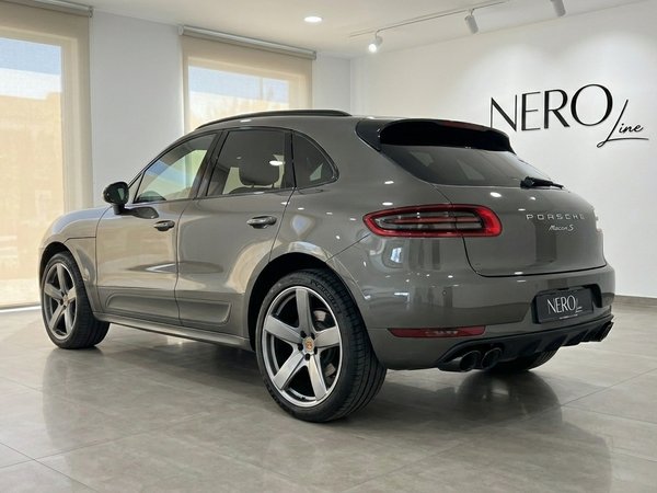 Porsche Macan 2.0 Turbo — Rear three-quarter view A gloss Volcano Grey Metallic Porsche Macan 2.0 Turbo is showcased from a rear three-quarter angle in a bright Alicante showroom.