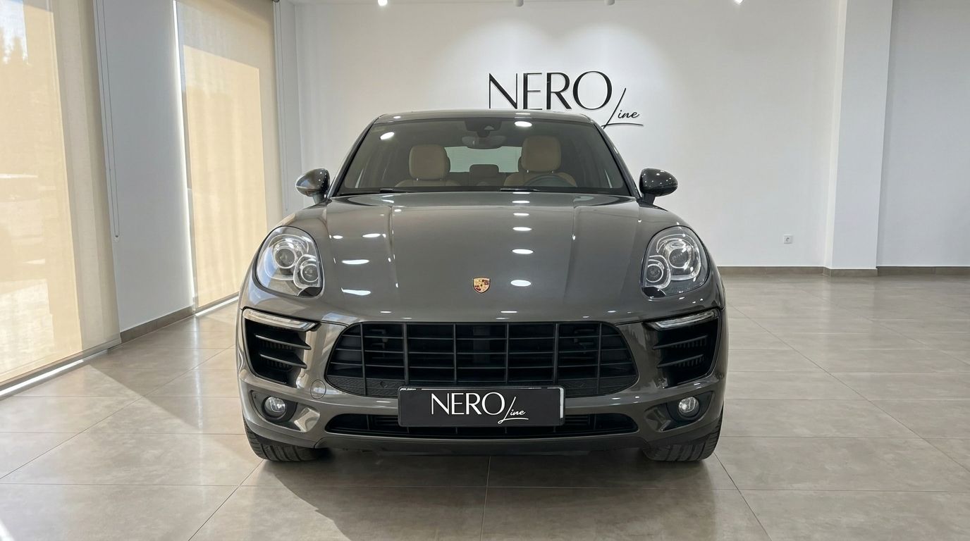 Front view of the gloss Volcano Grey Metallic Porsche Macan 2.0 Turbo in a bright showroom in Alicante.