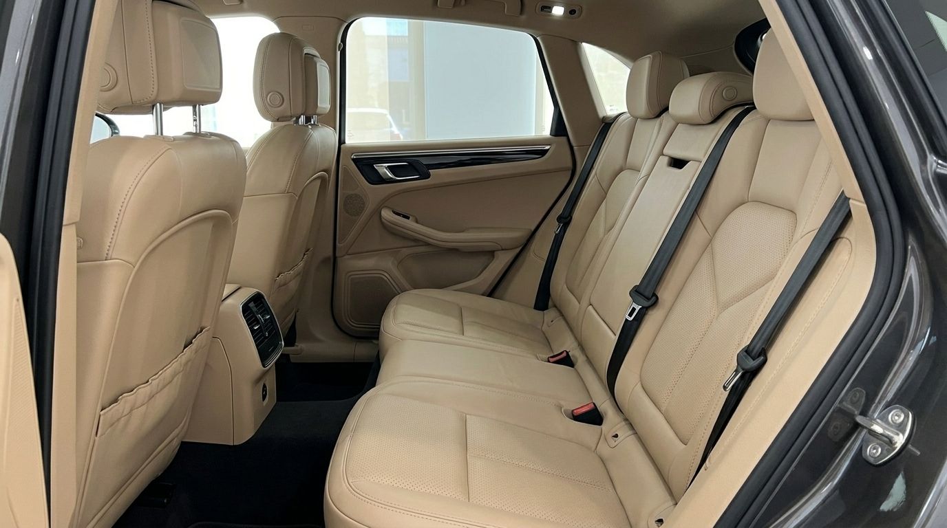 The luxurious beige leather rear seats and interior of the Porsche Macan 2.0 Turbo available for rent in Alicante.