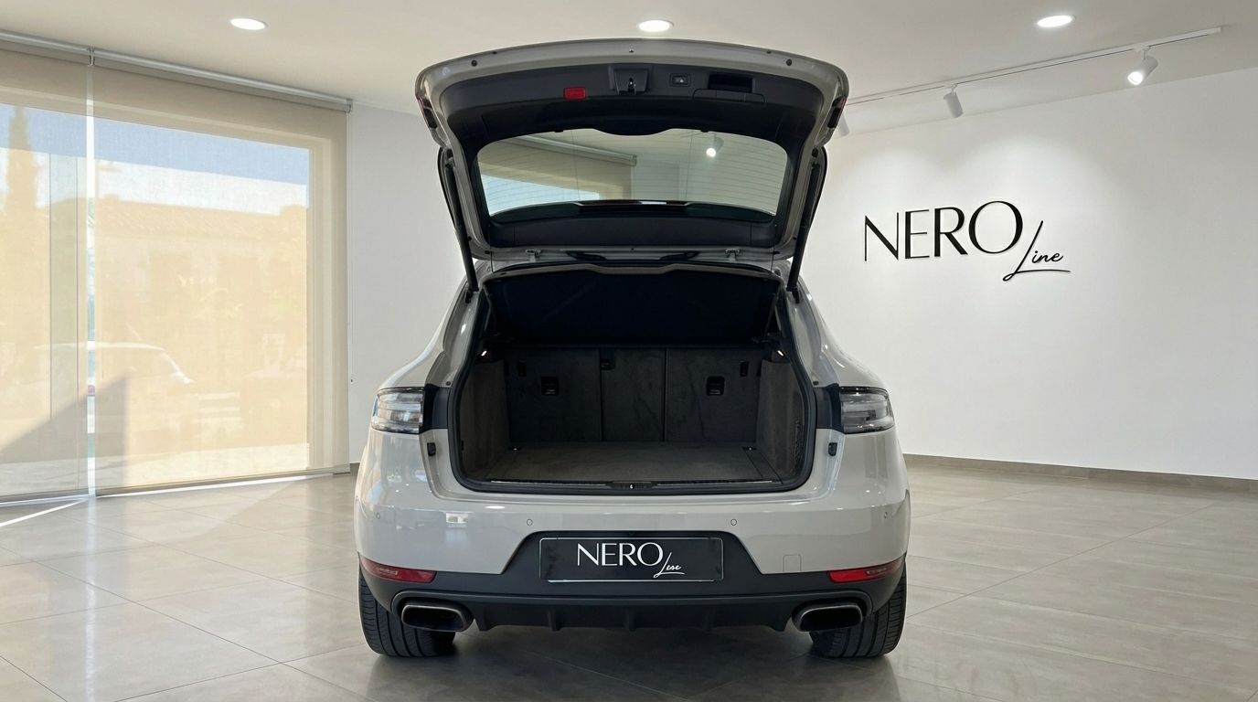 The light gray Porsche Macan S is shown from the rear with its trunk open, revealing ample cargo space in Alicante.