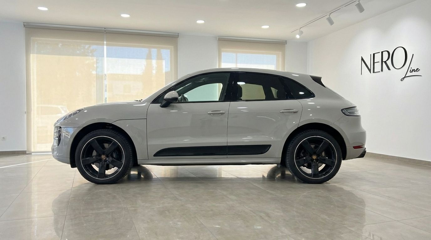 A light gray 2021 Porsche Macan S is shown from its side profile inside a showroom in Alicante.